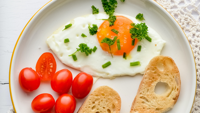 Ein Frühstücksteller mit Ei, Tomaten und Brot, dazu ein Text über ein gemeinsames Frühstück am 21. März um 10 Uhr