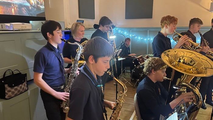 Students playing brass instruments in a classroom.