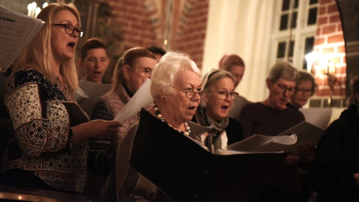 En gruppe af mennesker synger i en kirke