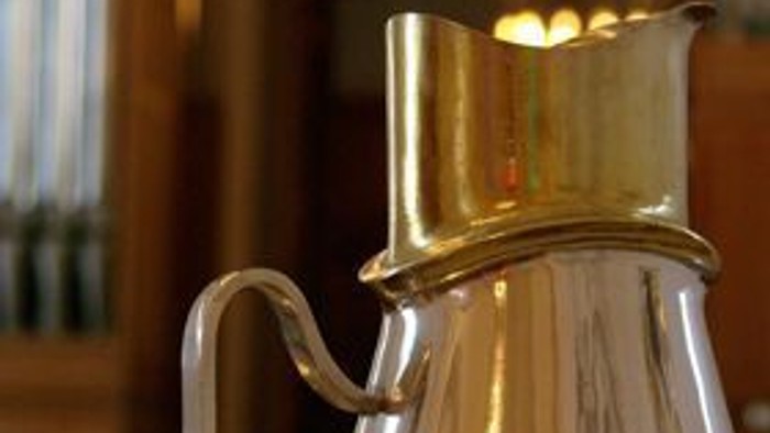 En glaspibe med guldfarvet hals og håndtag.