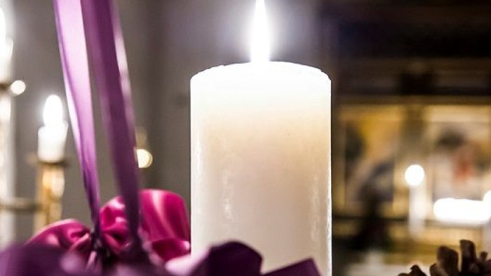 En lysende lyse med lilla bånd og en tannekrans