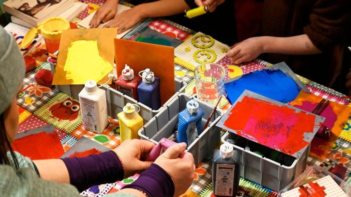 Kinder basteln an einem Tisch mit verschiedenen Materialien