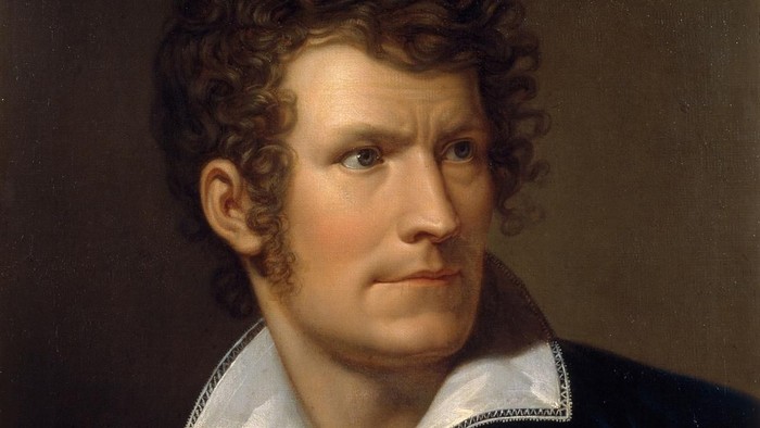 Portræt af en mand med kurve hår og hvid krage.