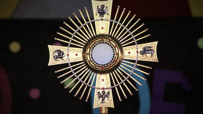Goldener Kelch mit religiösen Symbolen und Edelsteinen