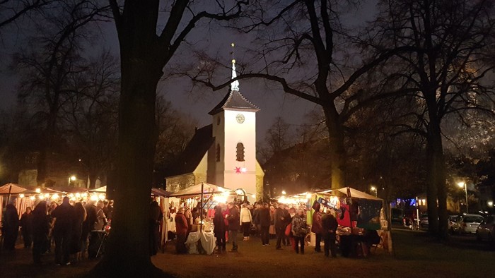 Nächtliche Veranstaltung vor Kirche mit vielen Menschen und Lichtern