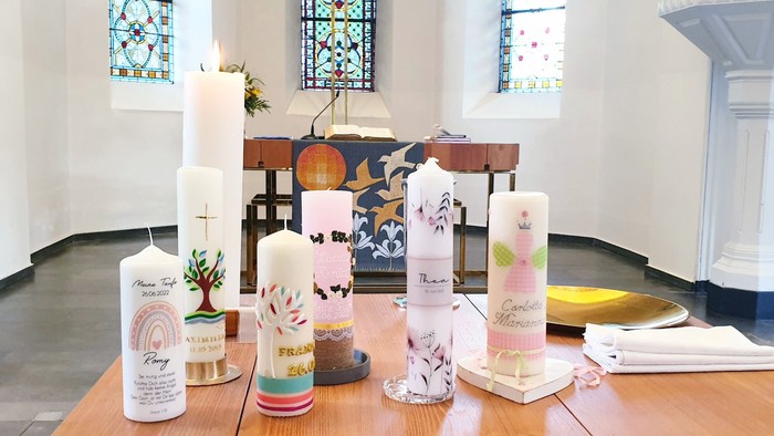 Bunte Kerzen und Dekorationen auf einem Tisch in einer Kirche