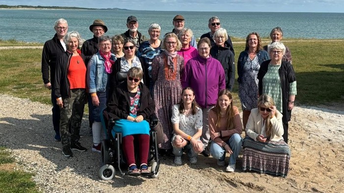 En gruppe af mennesker poser til et billede ved stranden