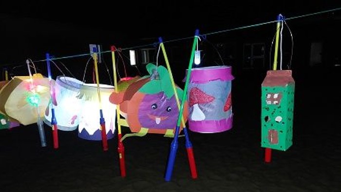 Bunte Laternen hängen an einer Leine im Dunkeln