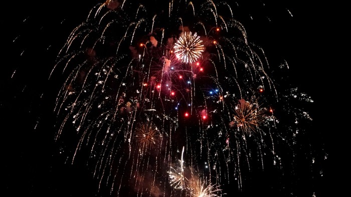 Feuerwerk explodiert am Nachthimmel und zeigt leuchtende Farben und Muster.