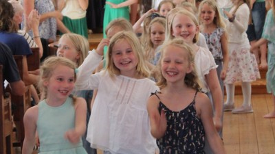 Børn danser i kirke.