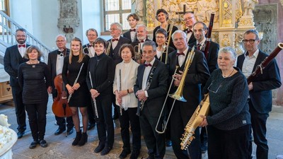 Ein Orchester posiert mit Instrumenten in einer Kirche