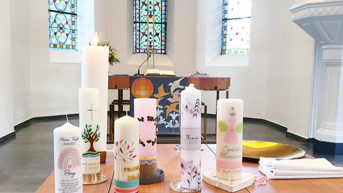 Bunte Kerzen und Dekorationen auf einem Tisch in einer Kirche