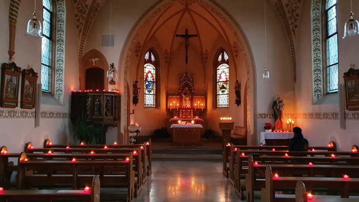 Innenraum einer Kirche mit Kerzen und Altarraum