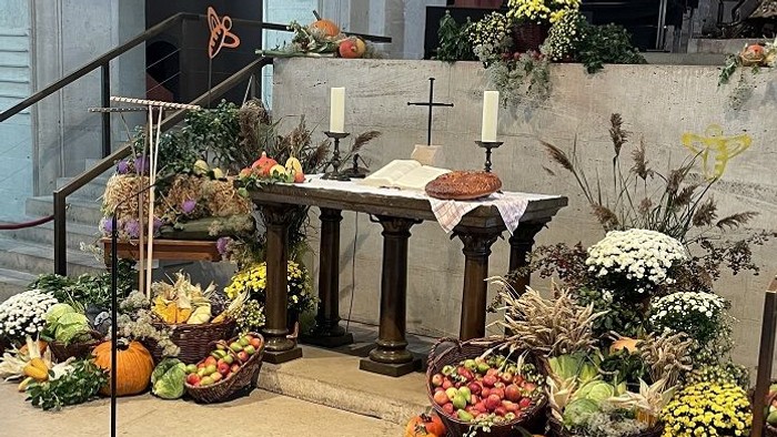 Prachtvolle Kirchendekoration mit Blumen, Kürbissen und Kerzen