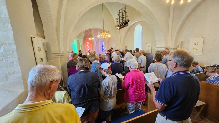 En folkemængde i kirke, der deltager i en gudstjeneste.