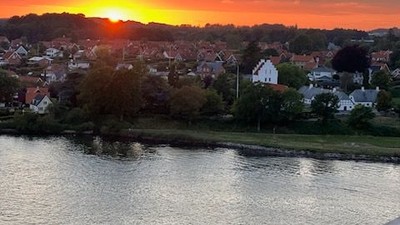 En smuk solgang over en by ved vandet