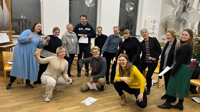 En gruppe af mennesker poser til et foto i et rum med juledekorationen.