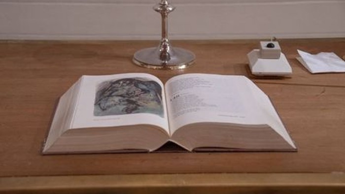 En åben bog og en vinglas på bordet