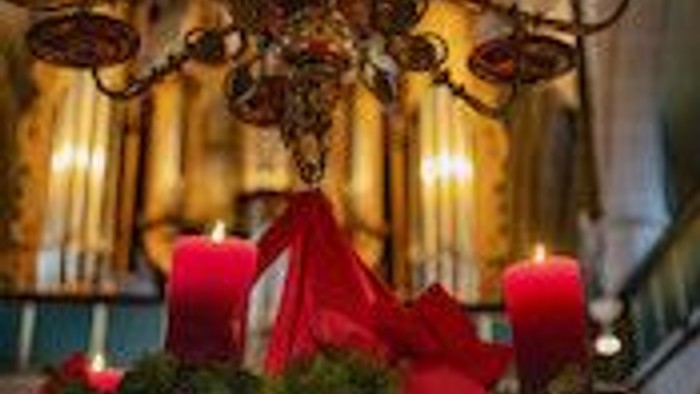 Adventskranz mit drei Kerzen vor einer Orgel