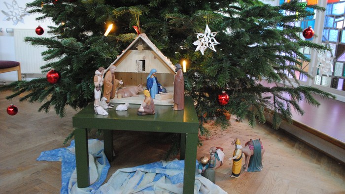 Ein Weihnachtsbaum mit Krippe und bunten Kugeln