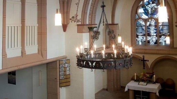 Kircheninneres mit gewölbten Decken, Kronleuchter und Buntglasfenstern