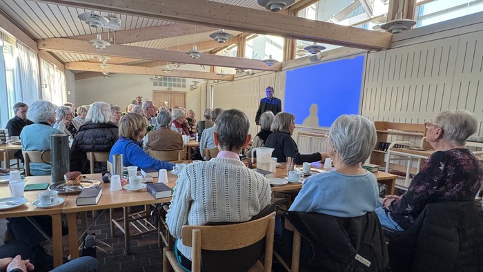 Forsamling af mennesker lytter til foredragsholder