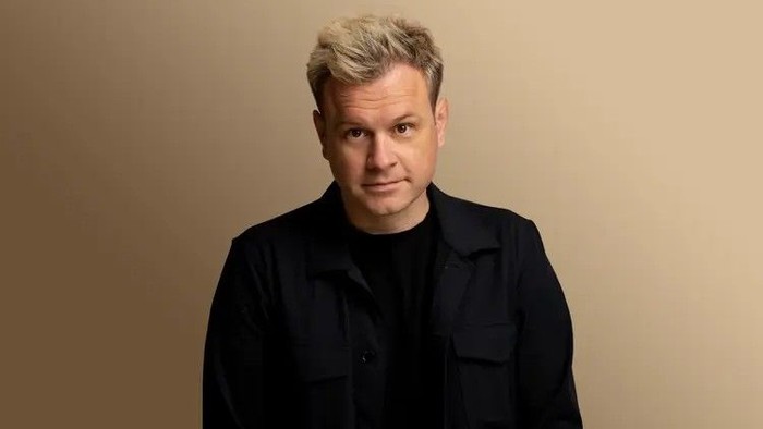 En mand med blondt hår iført en sort jakke.