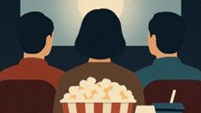 En gruppe mennesker ser en film i biografen med popcorn og drikkevarer