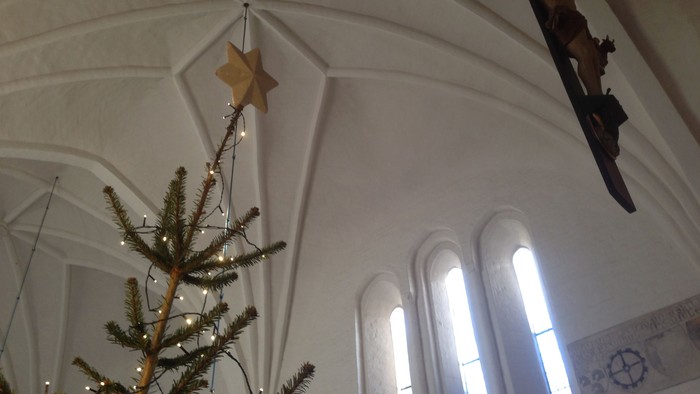 Kirkeinteriør med juletræ og stjerneudsmykning