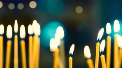 Mehrere brennende Kerzen in einer dunklen Umgebung