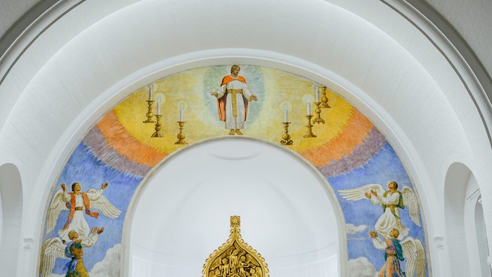 Billedet viser indersiden af en kirke med malerier af engle og religiøse scener.