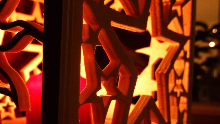 Dekorative Holzschneeflocken vor Fensterscheibe