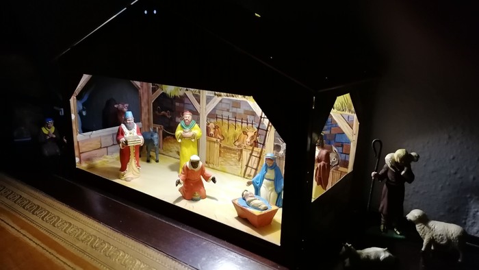En lille nissebob og et skærmbillede af en juleopstilling med figurer.