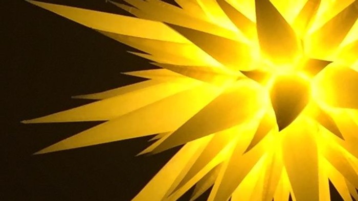 Leuchtender gelber Stern vor schwarzem Hintergrund