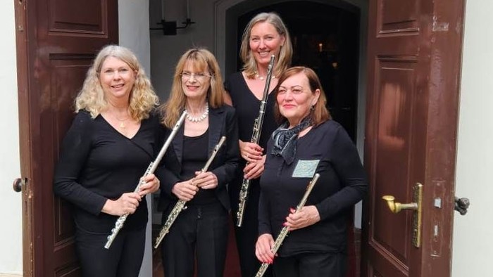 Vier Frauen mit Musikinstrumenten vor Tür