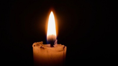 En ensom lille lyse candlestick i mørke.