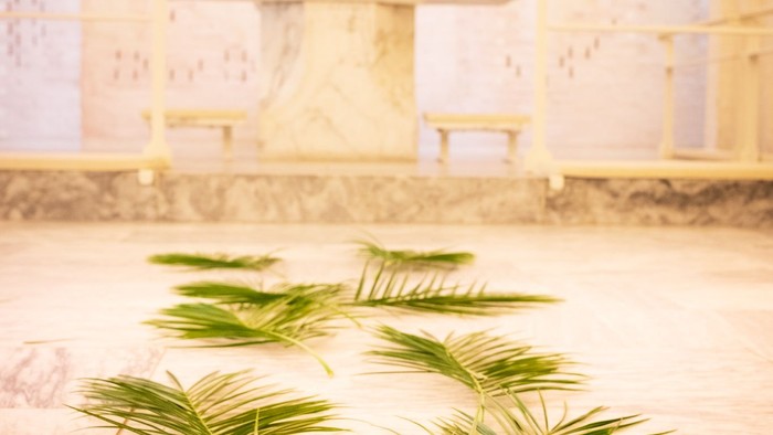 Elegant kirkealter pyntet med palmegrene og lys, sat mod en rolig baggrund.