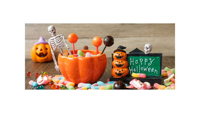 Ein Halloween-Dekoration mit Kürbislaternen, Knochen und Süßigkeiten.