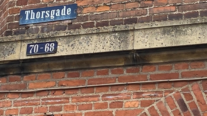 Bygning med mursten og gule tal- og navnetavler