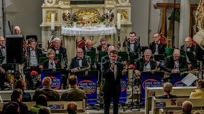 Ein Orchester spielt in einer Kirche, ein Mann dirigiert.