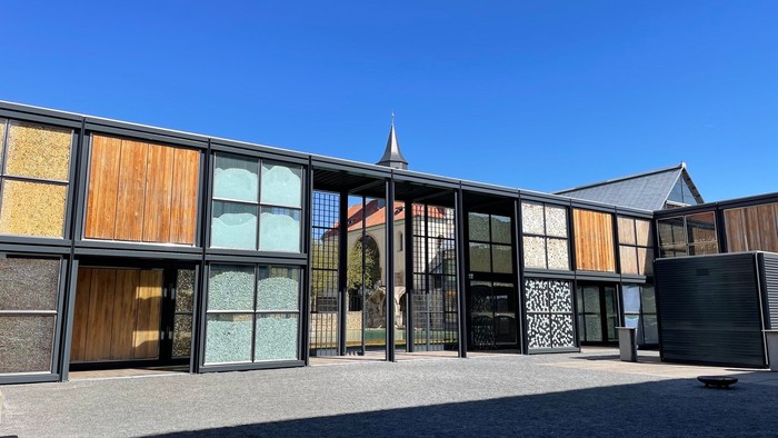 Moderne Gebäude mit großen Fenstern und Holzfassade unter klarem Himmel