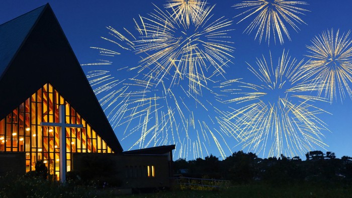 Kirke oplyst af fyrværkeri på himlen