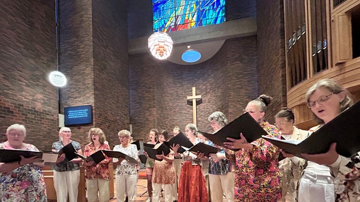 En gruppe af ældre kvinder synger i en kirke