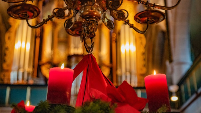 Kronleuchter mit roten Kerzen und Grünzeug, wahrscheinlich für Weihnachten.