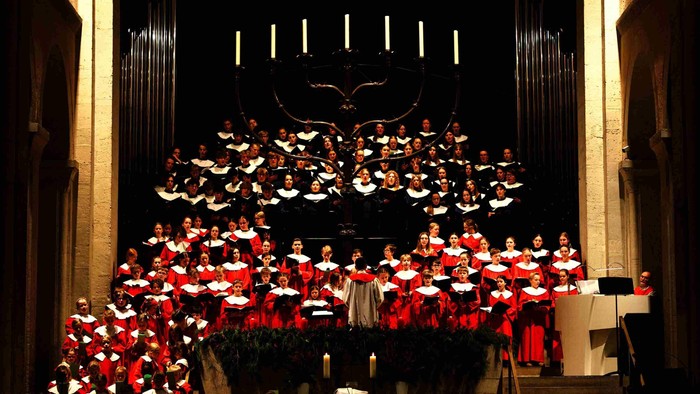 Ein großer Chor singt auf einer Bühne in einer Kirche