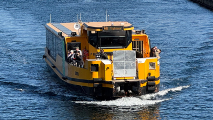 En gult færge sejler gennem en kanal i en by.