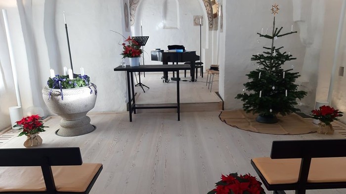 Indre del af kirke med juldekorationer og piano