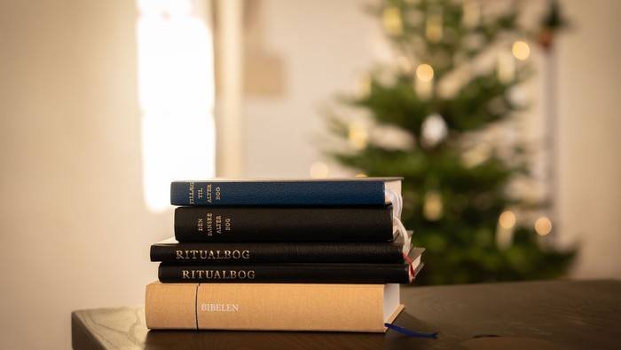 Stak af bøger foran juletræet