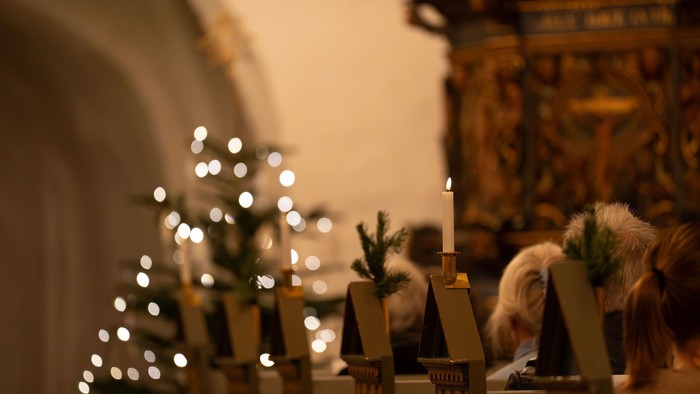 Juletræ med lys og stearinlys i kirken