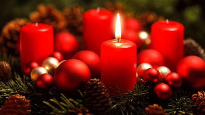 En juledekorasjon med røde lysende lysstaker, glitrende kugler og grønne nåler.